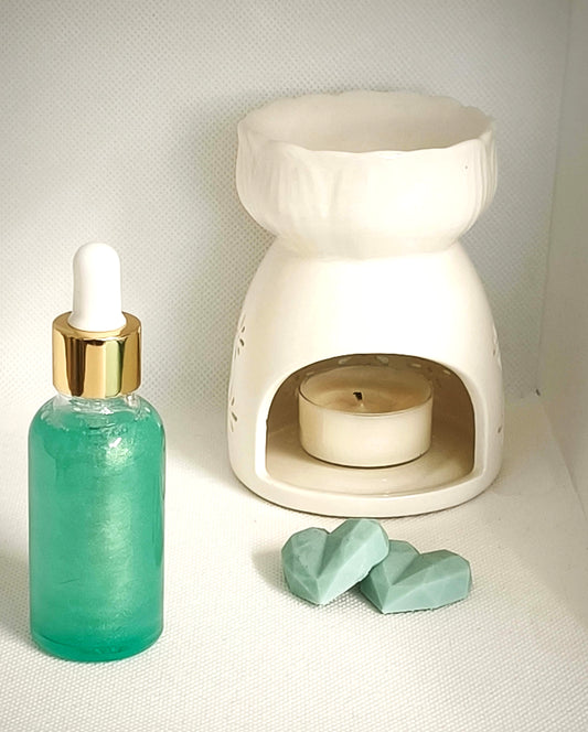 Liquide parfumé Menthe en flacon avec pipette, présenté à côté d’un brûleur blanc et de deux fondants