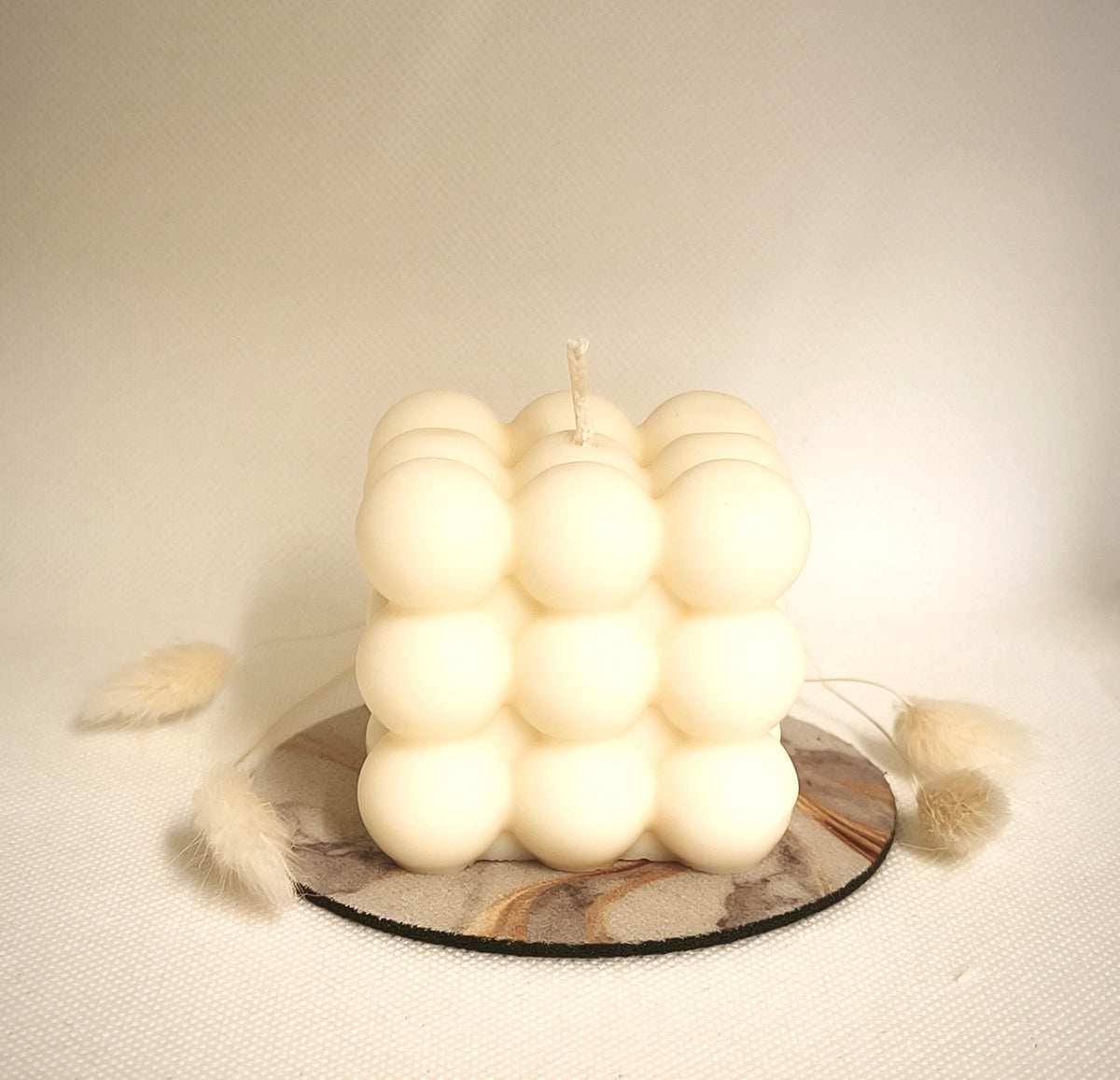 Bougie moulée ORBI multiboules blanche présentée dans une ambiance douce