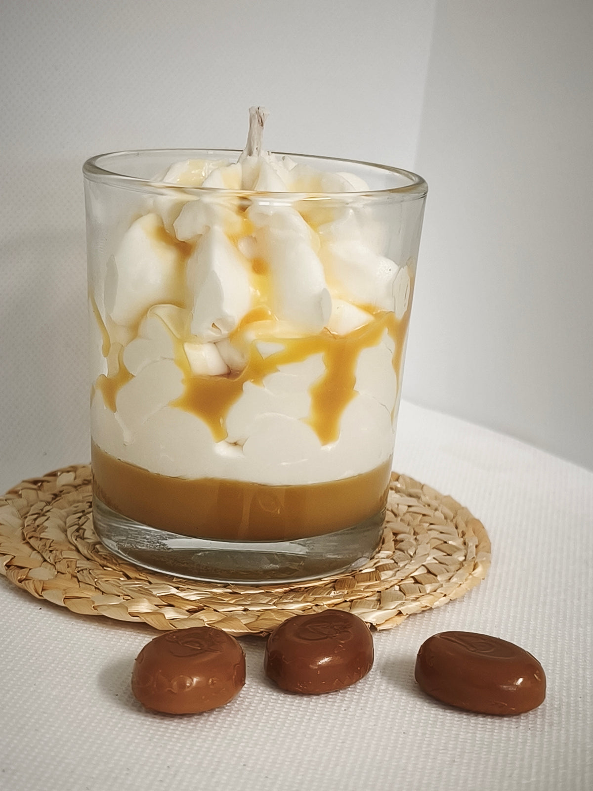 Vue rapprochée de la bougie Caramel en verre et de son décor effet chantilly